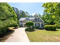 Charming two-story home featuring lush landscaping and a curved driveway at 2301 Kirk Farm Nw Pl, Kennesaw, GA 30152