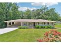 Charming single-story home featuring a covered carport, manicured lawn, and blooming flower beds at 3248 Wildwood Sw Dr, Marietta, GA 30060
