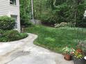 A lush, green backyard featuring a well-maintained lawn, landscaping, and a glimpse of a wooden fence at 1205 Rivershyre Ne Pkwy, Lawrenceville, GA 30043