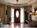 Elegant foyer with hardwood floors, a decorative chandelier, and a beautifully stained front door with sidelights at 1205 Rivershyre Ne Pkwy, Lawrenceville, GA 30043