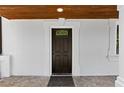 Elegant front door entrance featuring a dark wood door, stone tile porch, and pristine white columns and trim at 1887 Shalimar Dr, Atlanta, GA 30345