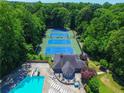 Aerial view of community pool, clubhouse and tennis courts surrounded by lush green trees at 2628 Amberly Dr, Dunwoody, GA 30360