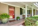Welcoming front porch with a red front door, ample seating, and decorative plants at 1448 Diamond Head Cir, Decatur, GA 30033