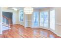 Bright dining area with hardwood floors, a large chandelier, and large windows with plantation shutters at 251 Waterford Cove Dr, Suwanee, GA 30024