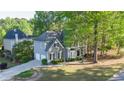 Beautiful gray two-story home with an attached two-car garage and mature trees, enhancing curb appeal at 251 Waterford Cove Dr, Suwanee, GA 30024