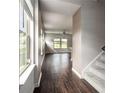 Inviting hallway with dark hardwood floors leads to a bright living area with large windows at 4627 Piston Sw Jct, Mableton, GA 30126
