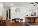 View of the entry and kitchen area with bar seating, hardwood floors, and decoratively paneled wall at 1202 Key Se Rd, Atlanta, GA 30316