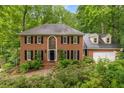 Charming brick home featuring a beautifully landscaped front yard and a classic, symmetrical design at 355 Highlands Trce, Roswell, GA 30075