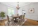 Bright dining room features a chandelier, tray ceiling, and large window for natural light at 576 Cliftwood Ct, Sandy Springs, GA 30328