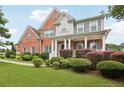 Lovely brick home featuring a well-manicured yard and inviting front porch with columns at 112 Tara Blvd, Loganville, GA 30052