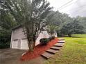 View of the home and its two-car garage from the side yard at 80 Brooks Ln, Dallas, GA 30157