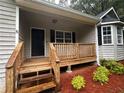 Covered front porch of home with wooden deck and railing at 80 Brooks Ln, Dallas, GA 30157