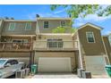 Rear exterior showing a two-story townhome with a balcony, back entry garages, and ample parking space at 234 Riverstone Commons Cir, Canton, GA 30114