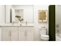 Well-lit bathroom featuring dual sink vanity, framed mirror, elegant fixtures and neutral wall art at 2464 Cotton Ln, Douglasville, GA 30135