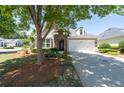Inviting home showcasing a stone entrance, white garage doors, and lush green lawn at 6350 Manningtree Ct, Cumming, GA 30041