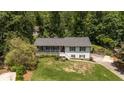 Split-level home nestled on a tree-lined lot, featuring a charming front porch and landscaping at 2795 Bentwood Dr, Marietta, GA 30062