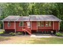 Charming red home with a cozy front porch and well-maintained landscaping, offering a welcoming curb appeal in a serene neighborhood at 4771 N Springs Nw Rd, Kennesaw, GA 30144