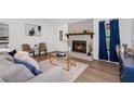 Bright living room with a stone fireplace, wood flooring, and neutral paint provides a cozy feel at 4771 N Springs Nw Rd, Kennesaw, GA 30144