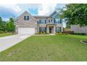 Beautiful brick home with a lush green lawn, complemented by black shutters and a charming front porch at 5789 Creek Indian Dr, Sugar Hill, GA 30518