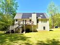 View of the rear exterior of the home with a large deck and solar panels on the roof at 96 Wildwood Dr, Temple, GA 30179