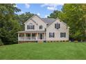 Charming two-story home with a spacious front yard and inviting covered porch at 25 Grange Ct, Sharpsburg, GA 30277