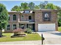 Charming two-story brick home with a well-manicured front yard and attached two-car garage at 4590 River Stone Trl, Douglasville, GA 30135