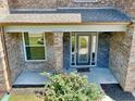 Close-up of the front door with sidelights, accented by stone and manicured landscaping at 4590 River Stone Trl, Douglasville, GA 30135