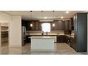Spacious kitchen featuring dark wood cabinets, a center island, and stainless steel appliances at 4590 River Stone Trl, Douglasville, GA 30135