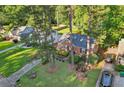 Aerial view of a brick home with a well-maintained lawn and mature trees in a quiet neighborhood at 1521 Deerwood Dr, Decatur, GA 30030