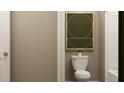 Stylish half-bathroom features a toilet with modern wall art, creating a simple yet elegant space at 2340 Treaty Ln, Douglasville, GA 30135