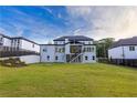 Expansive backyard featuring lush green lawn and exterior stairs leading to a covered porch at 2631 Sardis Way, Buford, GA 30519