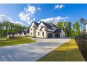 Spacious driveway leads to a charming two-story home with lush green lawn, offering ample parking and curb appeal at 2631 Sardis Way, Buford, GA 30519