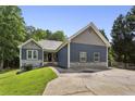 Charming home boasts a well-manicured lawn, blue siding, stone accents, and a long driveway leading to the residence at 735 Poplar Rd, Dallas, GA 30157