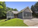 Charming home boasts a well-manicured lawn, blue siding, stone accents, and a long driveway leading to the residence at 735 Poplar Rd, Dallas, GA 30157