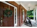 Inviting front porch featuring classic rocking chairs, a decorative wreath, and brick accents at 685 Sienna Dr, Cumming, GA 30040