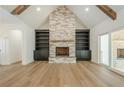 Bright living room with stone fireplace, wood beams, built-in shelves, and hardwood floors at 912 Oak Dr, Woodstock, GA 30189