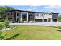 Modern home featuring black stone accents, a white facade, large windows, and manicured landscaping at 1336 Azalea Dr, Lawrenceville, GA 30043