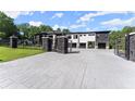 Modern home with black stone accents, white facade, and a large driveway with gated entrance at 1336 Azalea Dr, Lawrenceville, GA 30043