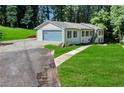 Single-Gathering home with blue garage door, front lawn and path to the front door at 2418 Bolling Brook Sw Dr, Atlanta, GA 30311
