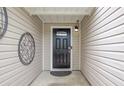 Inviting front entrance featuring a black front door with sidelights and decorative metal art at 468 Berkshire Place, Fairburn, GA 30213