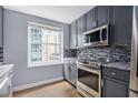Beautiful kitchen showcasing stainless steel appliances, gray cabinetry, and a window with city views at 195 14Th St # 902, Atlanta, GA 30309