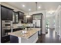 Eat-in kitchen features dark cabinetry, stainless steel appliances, granite countertops, and an oversized island at 345 Alderwood Ln, Sandy Springs, GA 30328
