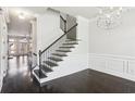 Staircase with wood and iron railings leading upstairs with a modern chandelier at 345 Alderwood Ln, Sandy Springs, GA 30328