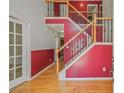 Inviting entryway with hardwood floors, featuring a staircase with decorative wrought iron spindles at 3524 Forest Downs Cv, Decatur, GA 30034