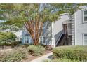 Light grey two-story condo featuring a well-manicured lawn and stairs leading to the upper level entrance at 72 Sutton Pl, Avondale Estates, GA 30002