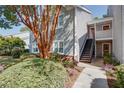 Light grey two-story condo featuring a well-manicured lawn and stairs leading to the upper level entrance at 72 Sutton Pl, Avondale Estates, GA 30002