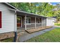 Charming front porch with brick accents and white railing, attached to a single-story home and garage at 11006 Clearwater Dr, Hampton, GA 30228