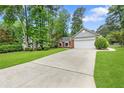 Lovely home with a long driveway, lush green lawn, and mature trees at 1208 Brandl Sw Dr, Marietta, GA 30008