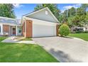 Well-maintained front yard showcasing the home's brick facade and attached two-car garage at 1208 Brandl Sw Dr, Marietta, GA 30008