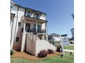 Beautiful multi-story townhome with a covered porch, brick base, and manicured lawn at 3564 Shore Wood Ave, Lawrenceville, GA 30044